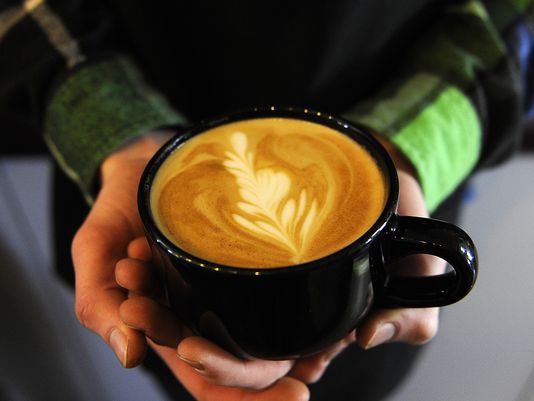 Calvin Hines holds a latte from River Road Coffee House. Photo: Sara C. Tobias/The Advocate